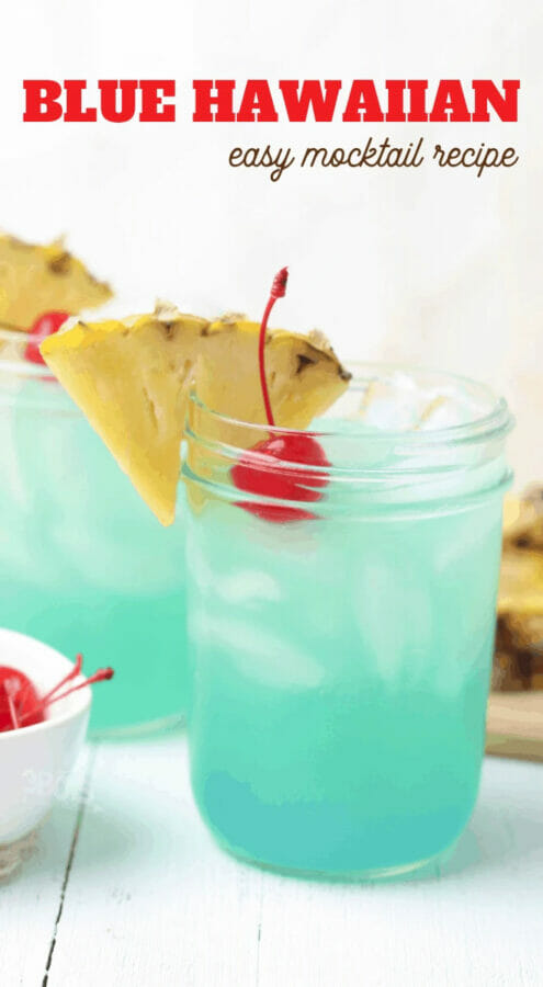 aqua colored drink in mason jar with pineapple and cherry