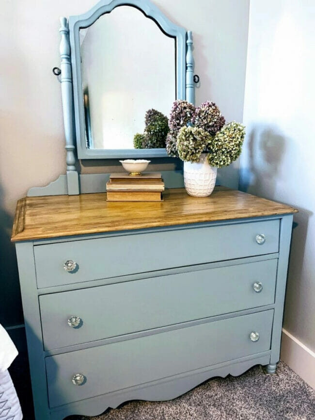 blue dresser with mirror and hydrangeas in vase