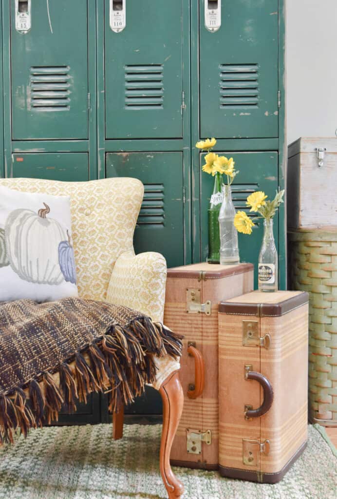 green lockers with suitcases sitting next to chair with blanket