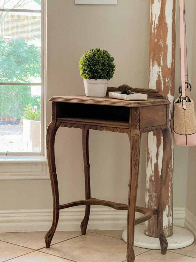 bleached wood table with purse, plant and window