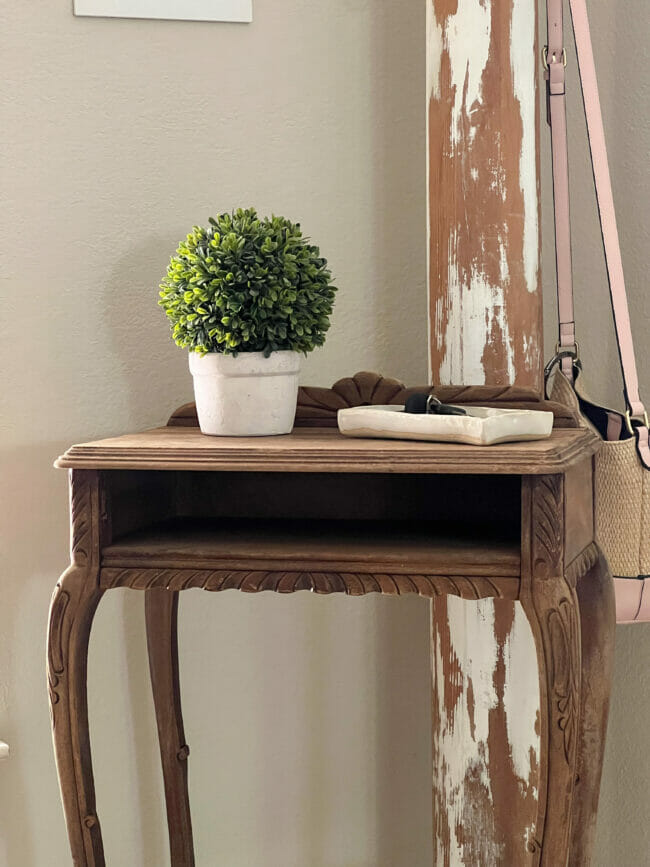 wood table in entry with plant and tray of keys