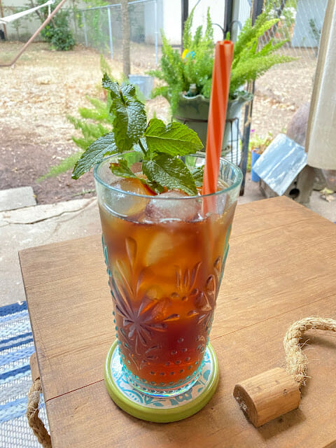 tea with mint in a blue glass with orange straw