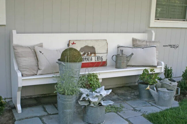 white pew with buckets of plants