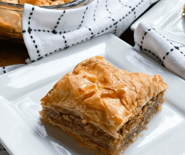 Piece of Baklaca on a plate with checked napkin