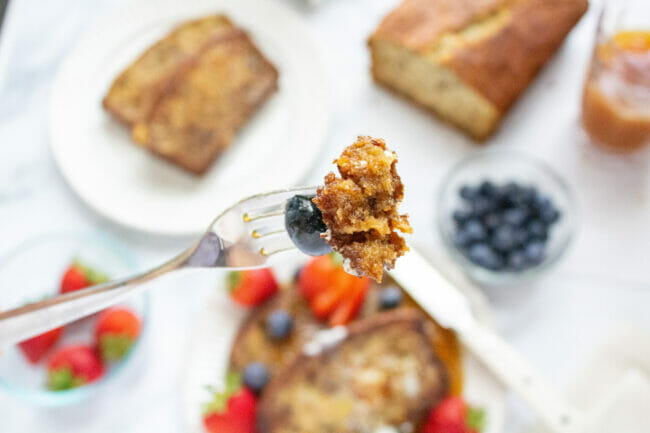 bite of banana bread on fork with blueberrie