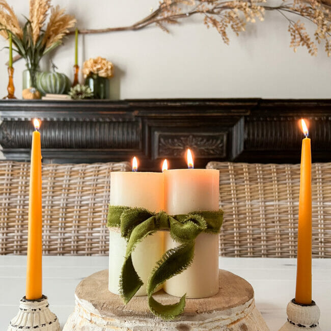 cream and gold candles with black mantel in background