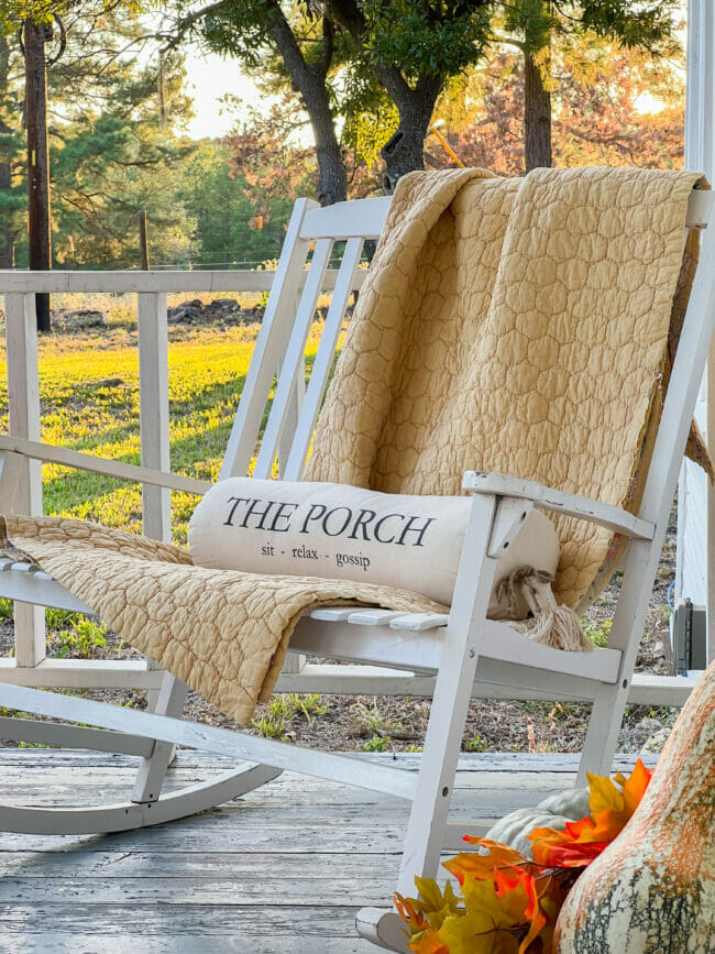 rocking bench with gold blanket and rolled lumbar pillow