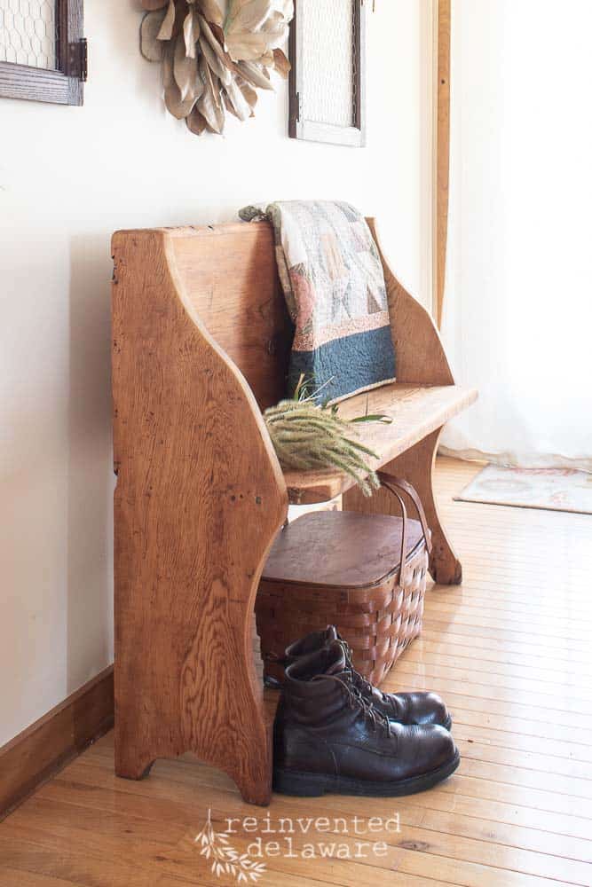 old church pew with boots, quilt and basket underneath