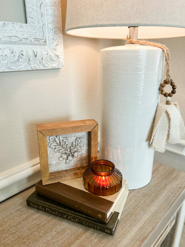 acorn in frame with bronze candle and white lamp