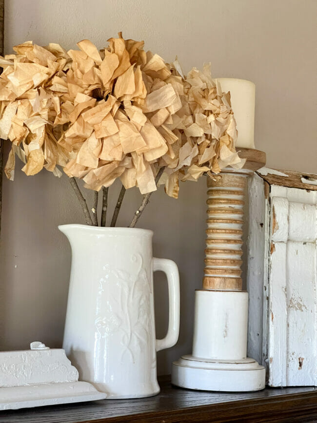 vintage pitcher with coffee filter flowers and a white candlestick