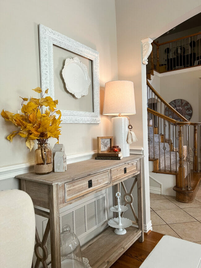 console table with lamp and fall stems in brown vase