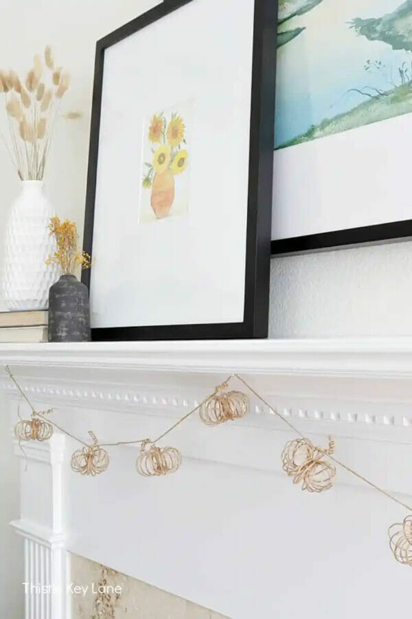 white mantel with neutral pumpkin garland and framed fall print