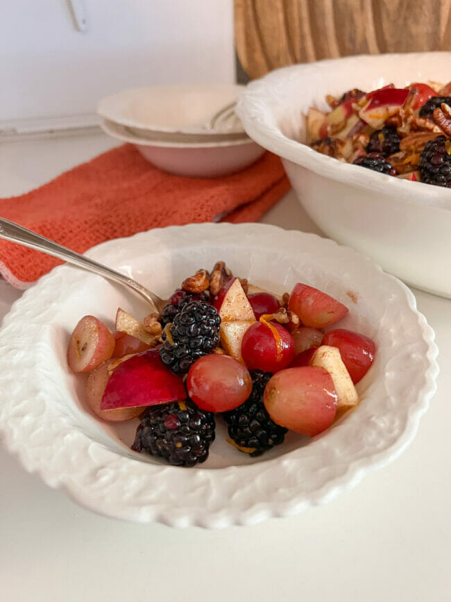 fruit salad in small white bowl with spoon