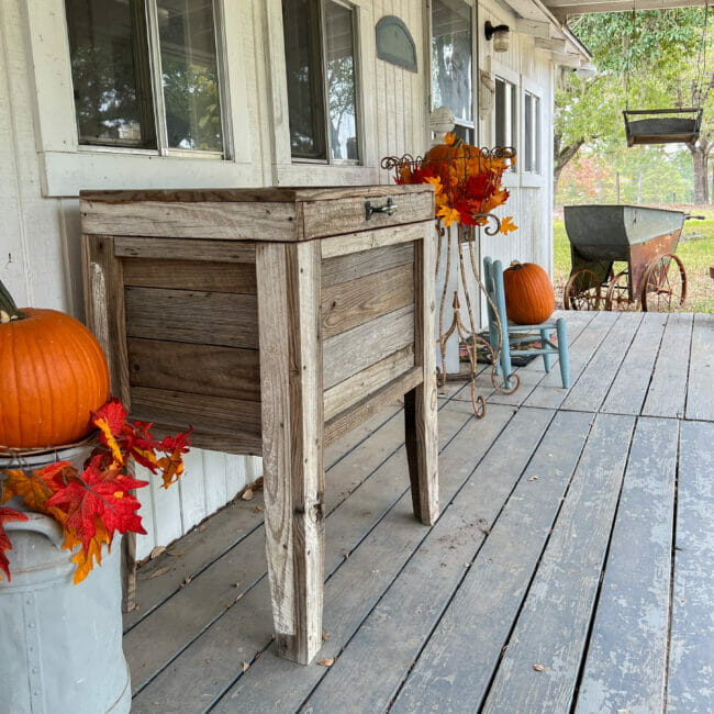 reclaimed wood ice chest with pumpkins on back porch