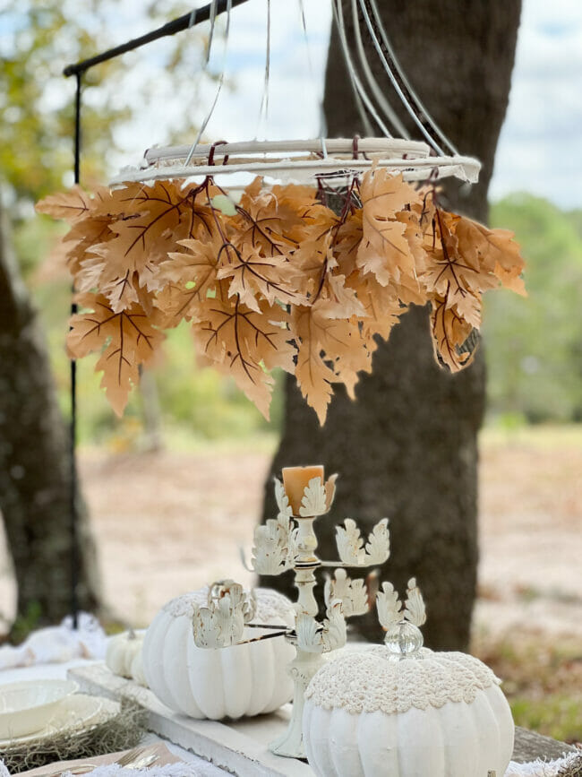 tan leaf chandelier with iron candelabra and pumpkins as centerpiece