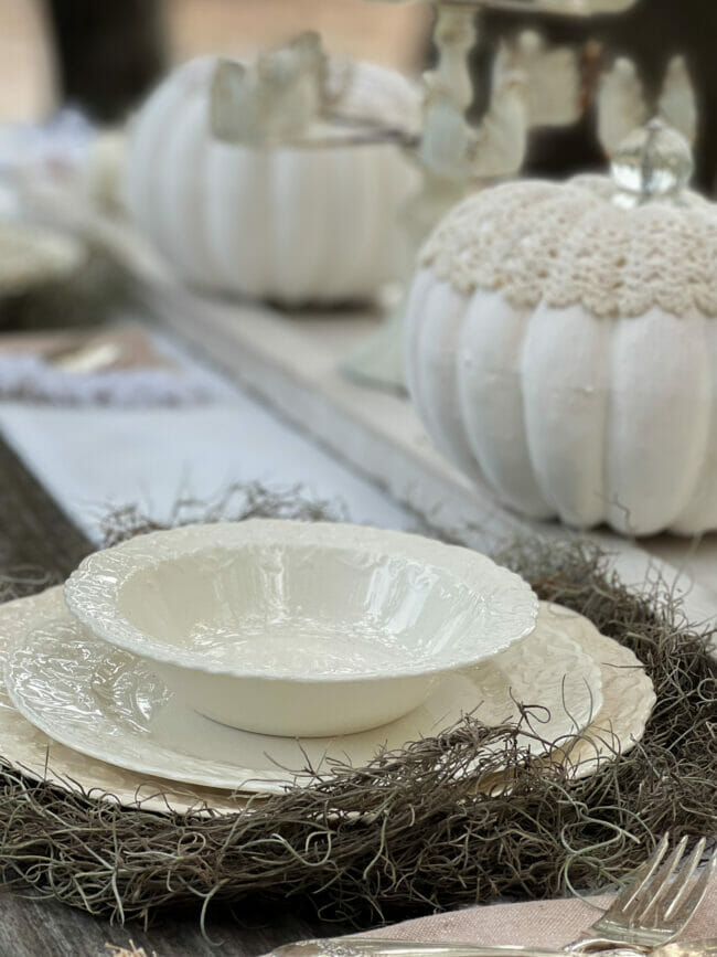 vintage white dishes on a Spanish moss charger