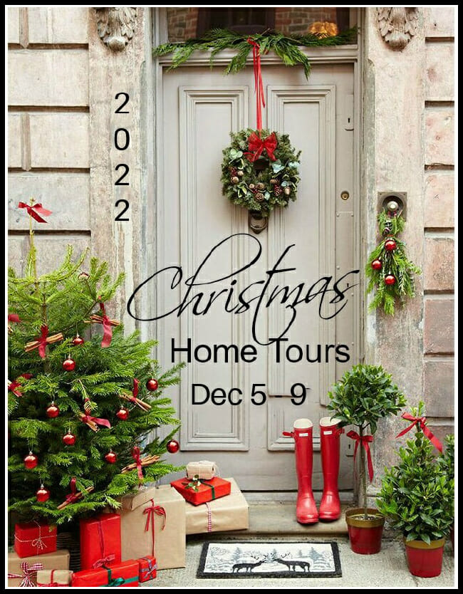 front door with bushes, red boots, and Christmas wreath on door