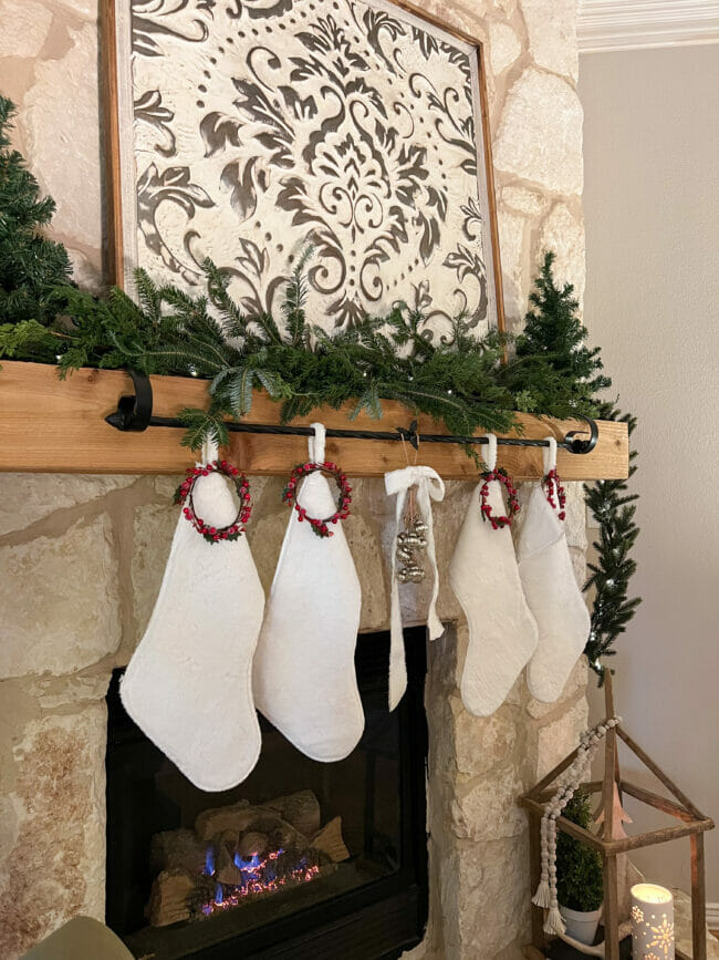 stone mantel with white stockings and greenery
