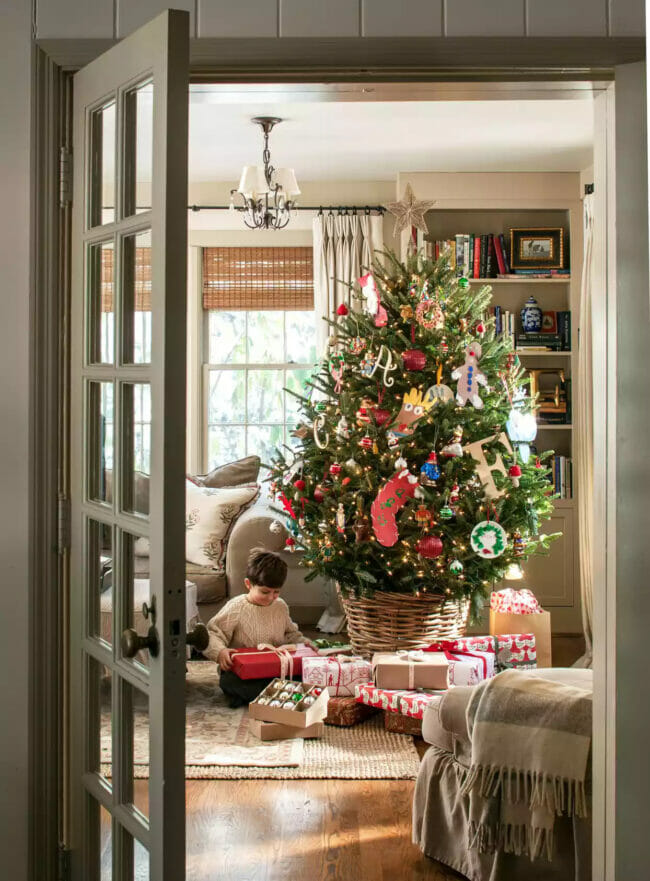 Kid under tree opening gifts