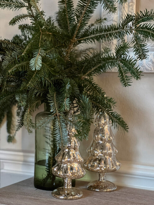 fresh greens in vase with mercury glass trees