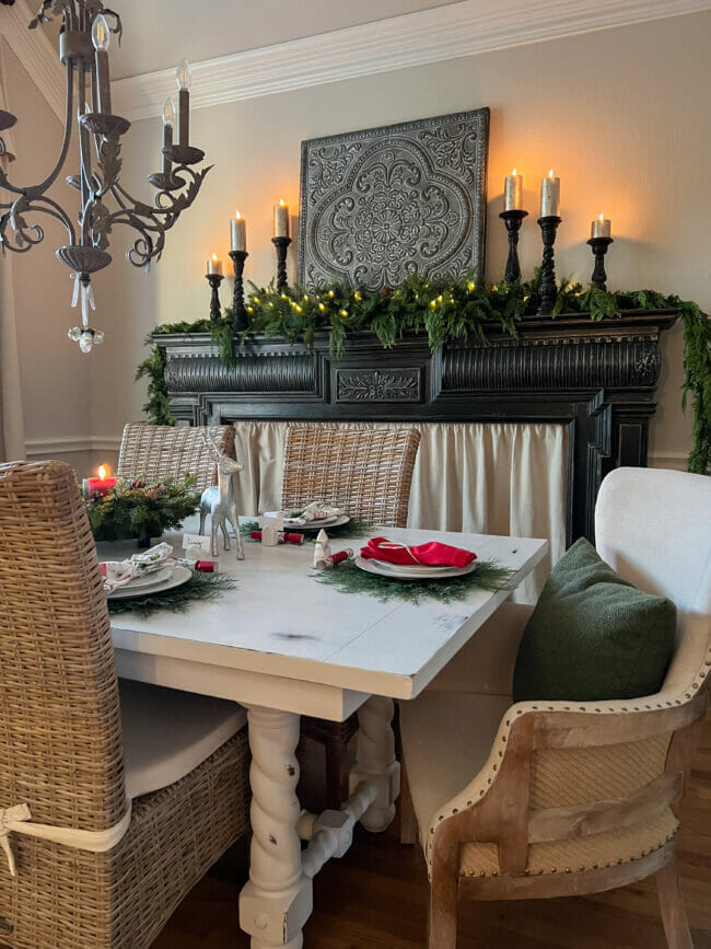 full Christmas dining room with black mantel and candlesticks and table setting