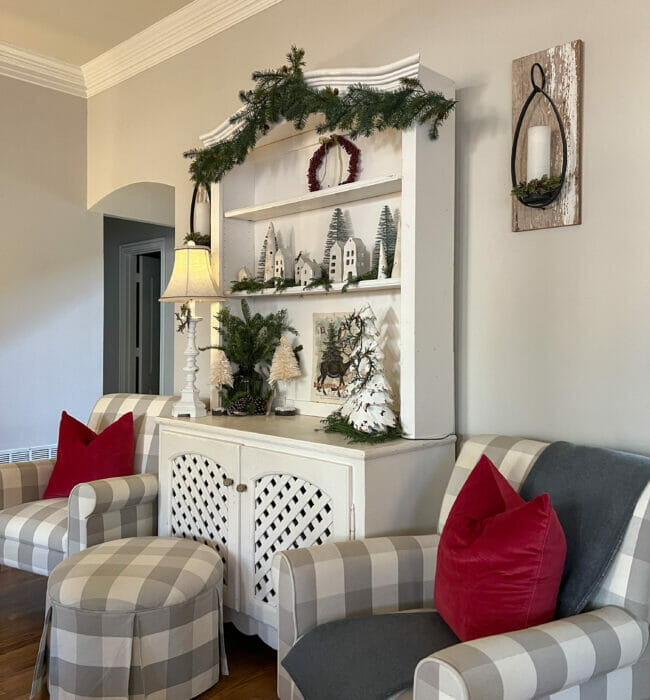 white hutch with gray checked chairs and red pillows