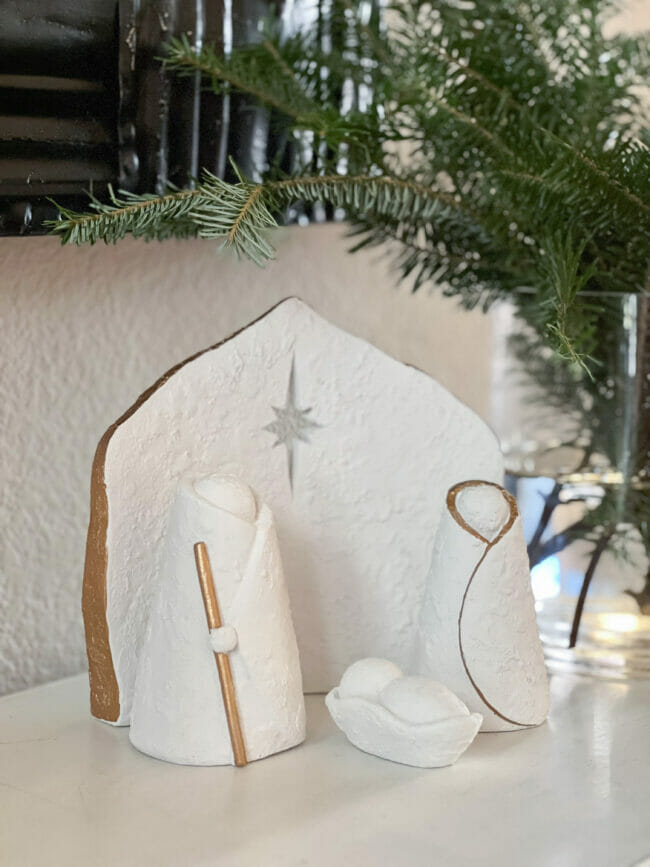 white and gold manger scene with fresh greens 