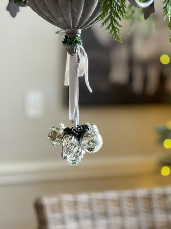 small silver glass ornaments hanging from chandelier 