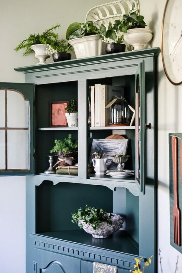 blue corner cabinet with books and decor