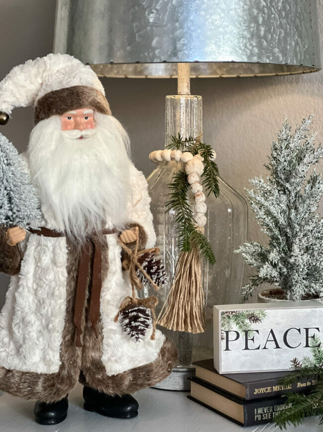 Santa with white coat, peace sign and trees with lamp
