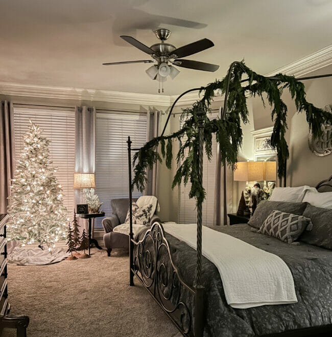 canopy bed with greenery, a Christmas tree and seating in front of windows