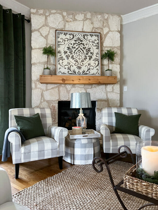 plaid chairs with ottoman sitting in front of stone fireplace