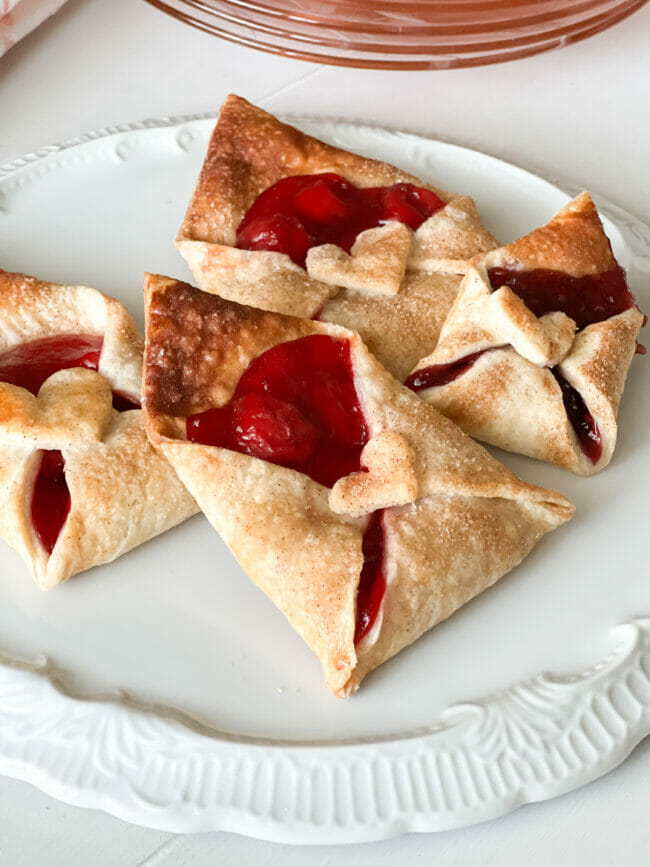 white plate with 4 cherry filled pastry envelopes