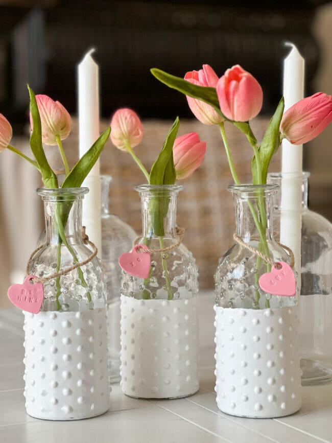 3 shite glass knobby vases and 2 white candles