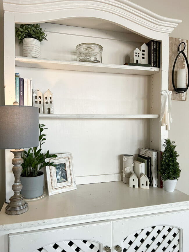 white hutch with lamp, plants, books and houses