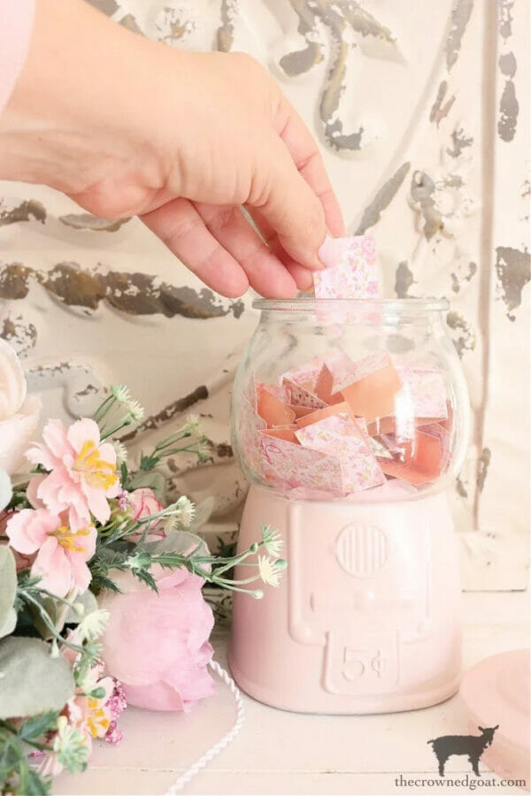pink candy jar with pink flowers and a hand inside jar