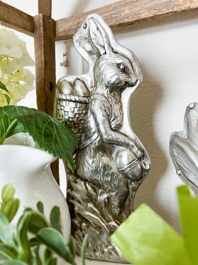 silver bunny with basket of eggs on back and greenery