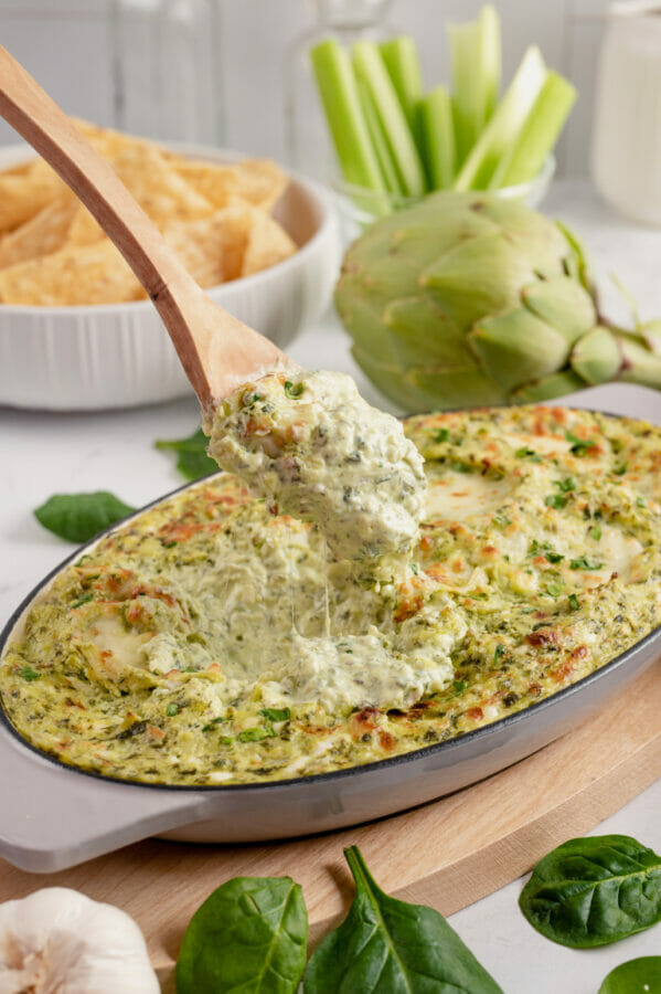 spinach dip with wooden spoon