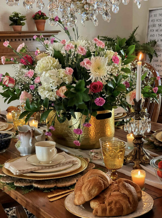 gold table accents with a pink and white real floral arrangement and candles