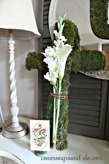 moss cross with lamp and flowers