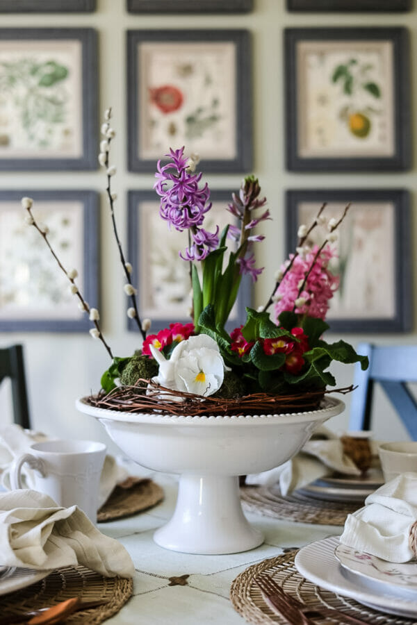 floral arrangement in white pedestal bowl on table