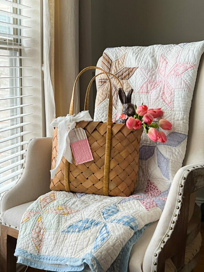 chair with quilt, basket, pink tulips and dark bunny