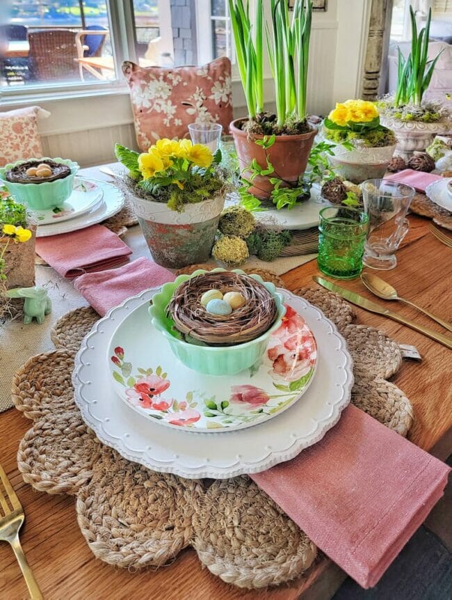 spring table with nests and yellow plants as centerpiece
