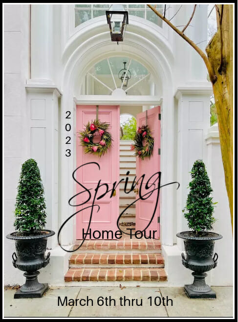 pink front door with wreaths and side topiaries