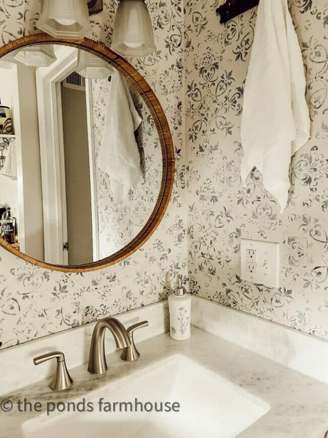 bathroom with stenciled walls , round mirror and sink