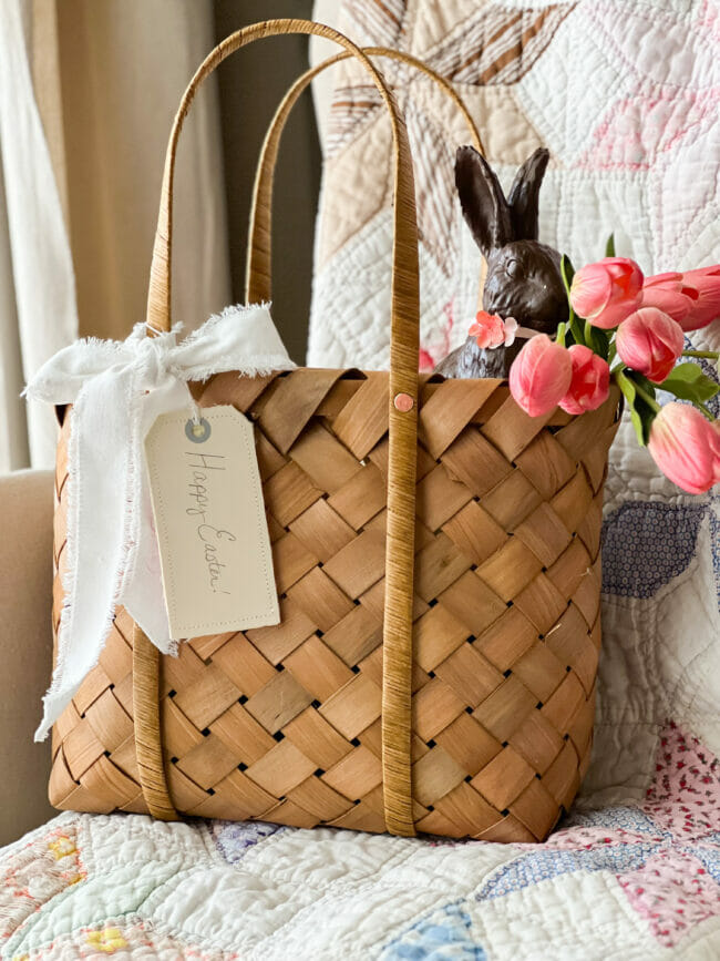 basket with pink tulips, white bow and dark bunny