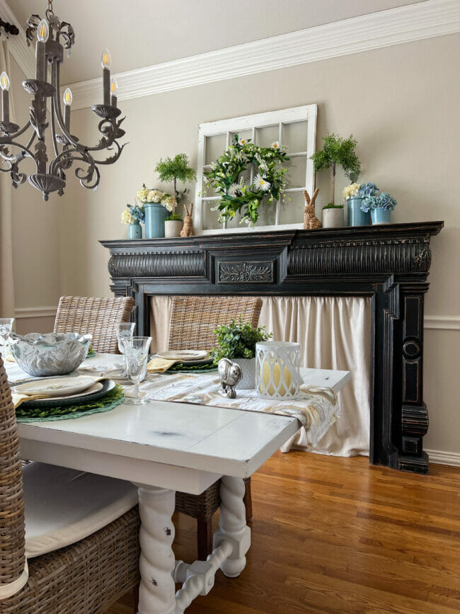 black mantel in dining room with greenery and flowers