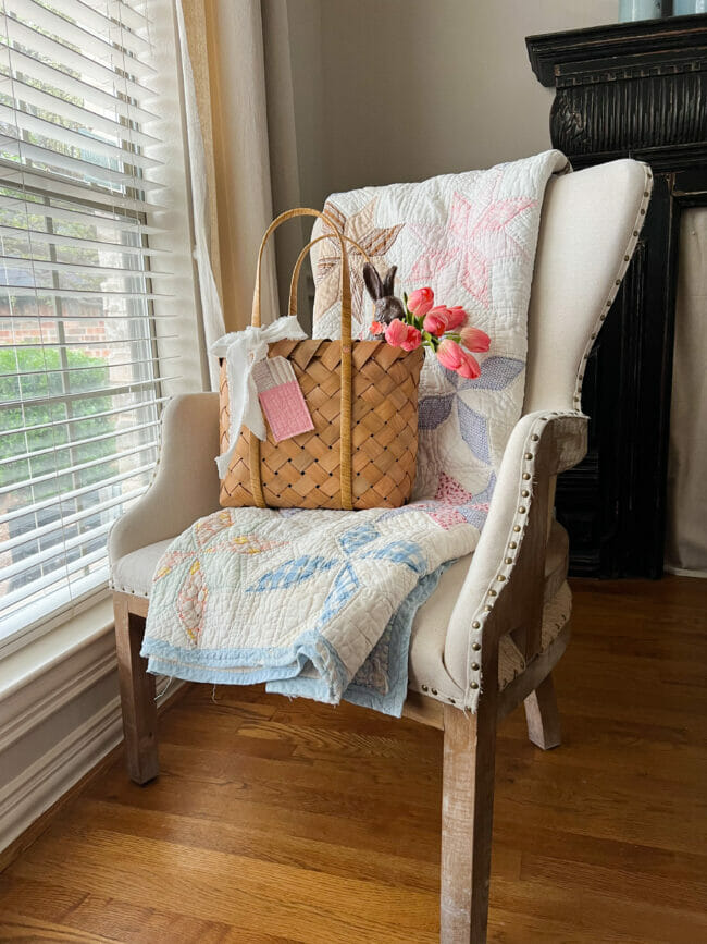 chair by window with basket, quilt and pink tulips