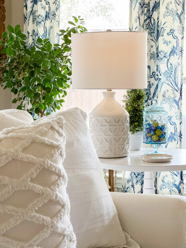 White pillows with lamp and blue curtains in background