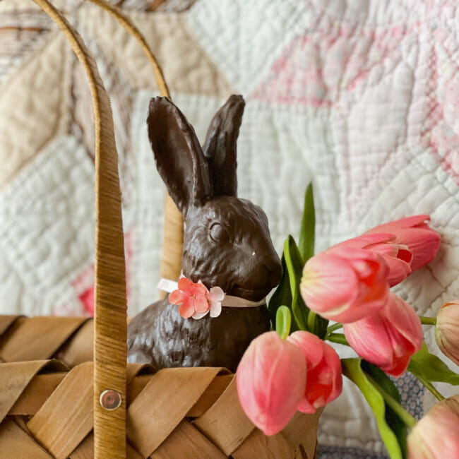 close up of choco bunny in basket with pink tulips